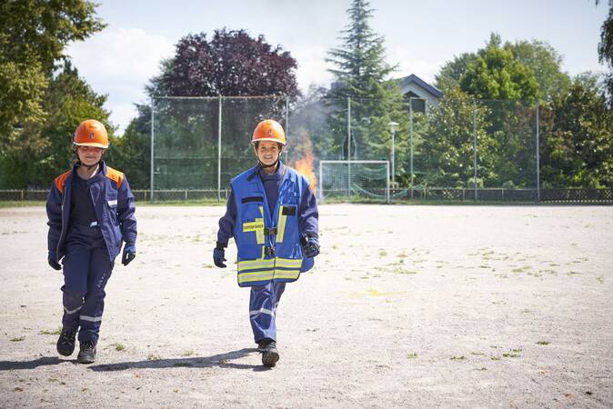 Die Gruppenführerin der Jugendfeuerwehr erkundet die Lage zusammen mit der Melderin bei einer Übung.