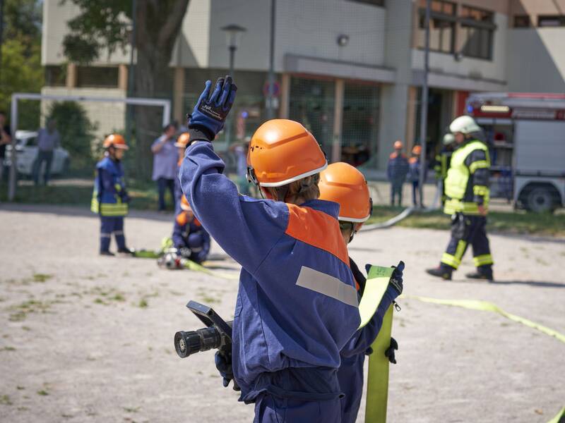 Ein Trupp der Jugendfeuerwehr mit einem Strahlrohr in der Hand.