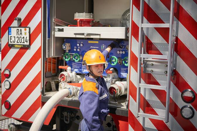 Jugendfeuerwehrjunge an der Pumpe des Hilfeleistungslöschgruppenfahrzeugs