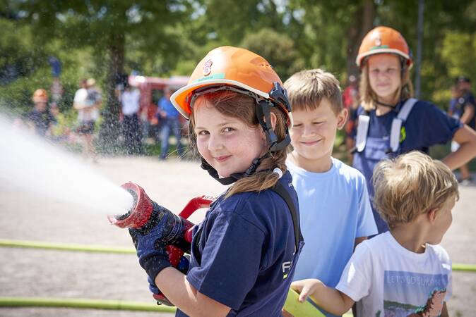 Jugendfeuerwehrmädchen bei der Wasserabgabe mit einem Strahlrohr